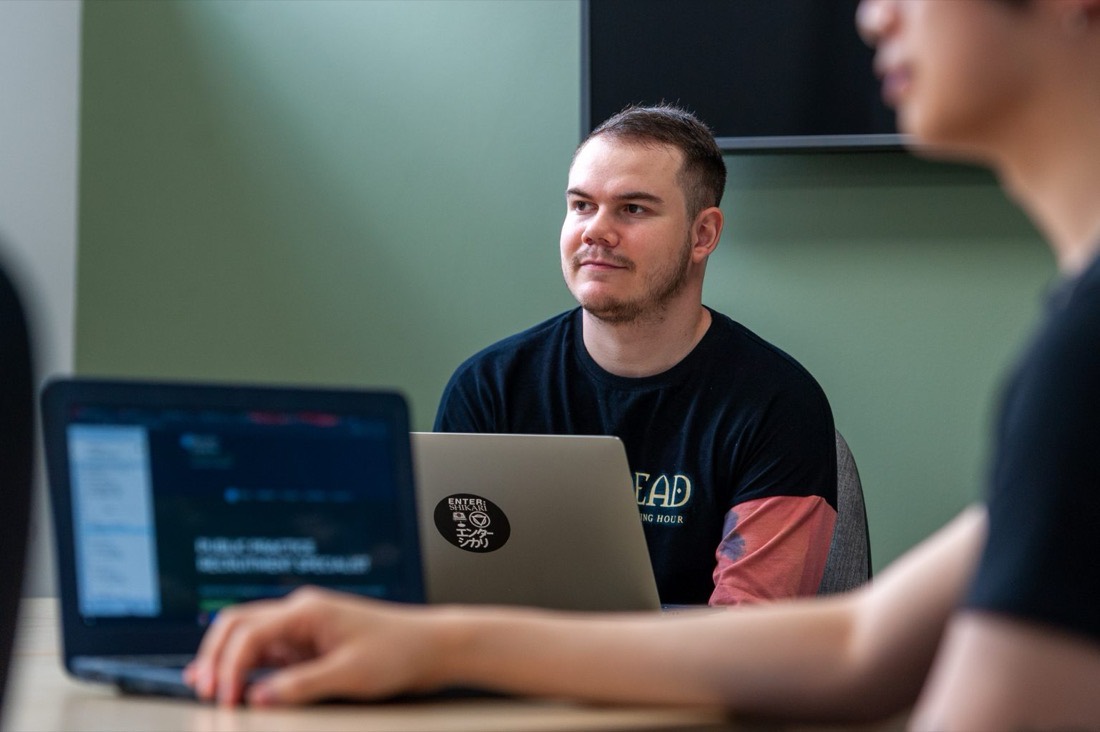 Benjamin Abbott sitting at a table with a laptop during a design session